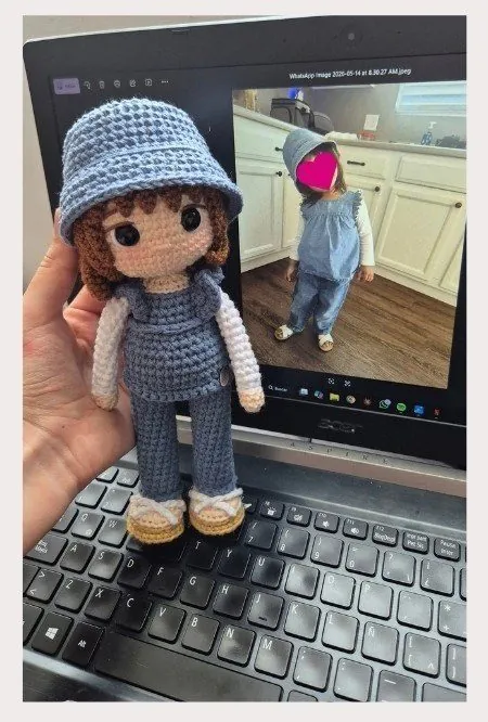 Niña con overol de jean y sombrero, junto a su amigurumi personalizado tejido a mano